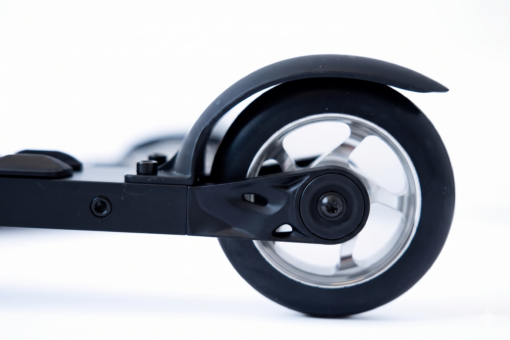 Close-up of a ROLLERSKI rear wheel with black fender, aluminum spoke Close-up of a ROLLERSKI rear wheel with black fender, aluminum spoke hub, and folding deck mechanism