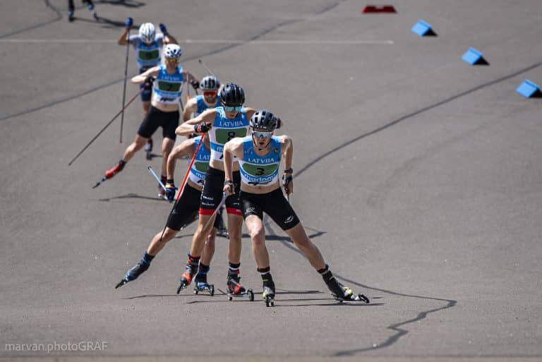 Rollerski race with Latvian athletes competing in group sprint on asphalt track