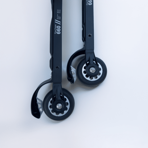 Close-up of two "FF Skis" scooter wheels, black with silver accents, mounted on a black "FF 660" frame. One wheel features a visible brake mechanism.