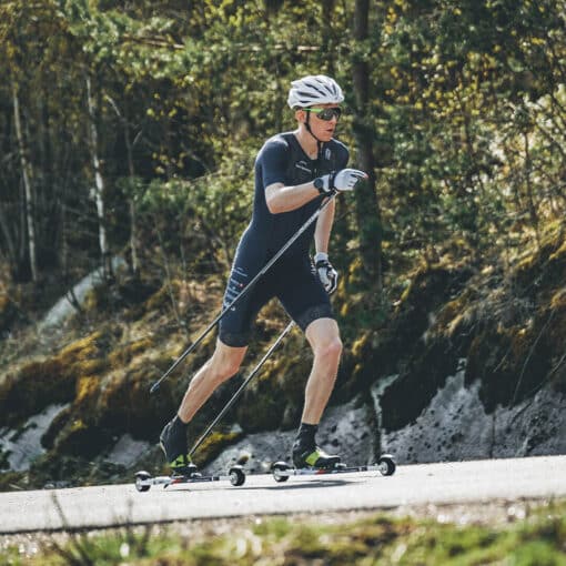 Skier using FF V Pro Classic rollerskis on a track, showcasing stability and high performance.